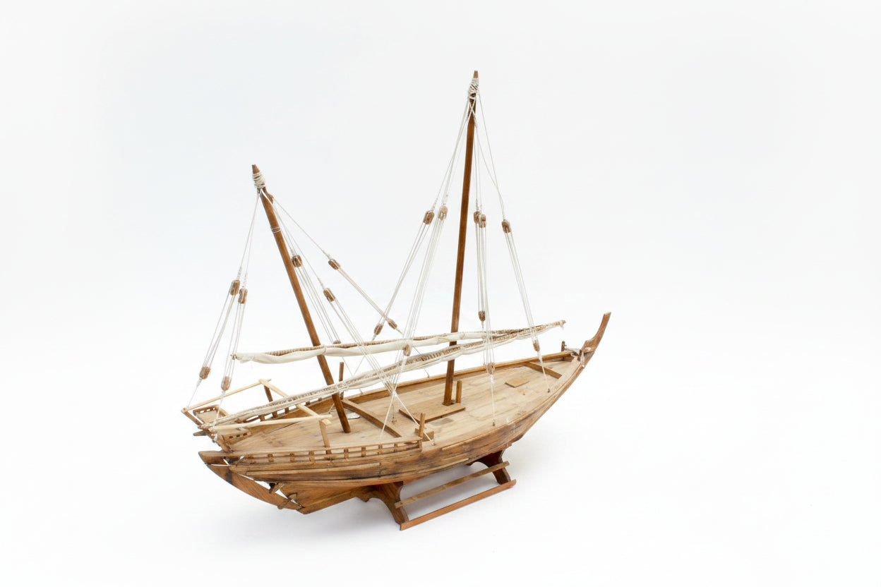 Wooden model sailboat on a white background